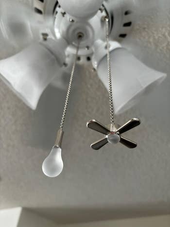 Ceiling fan with two pull chains: one with a bulb-shaped end, the other with a fan-shaped end, used for controlling light and fan speeds