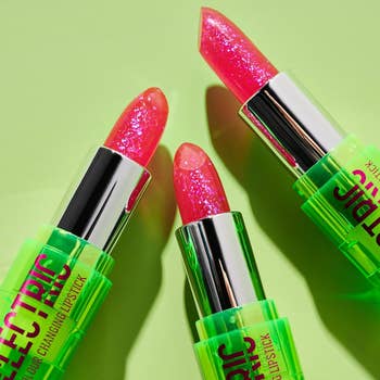 Three color-changing lipsticks with shimmer finish displayed against a green background