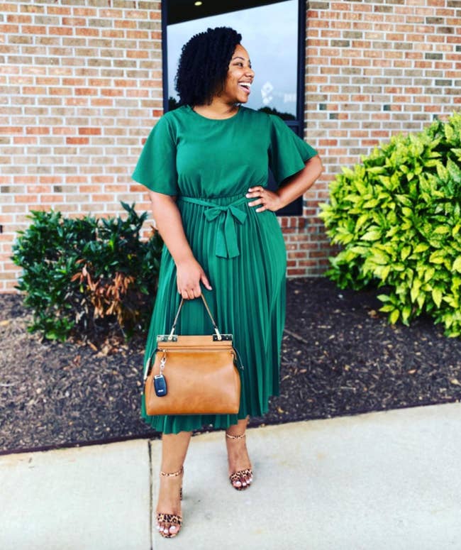 reviewer wearing the green midi dre