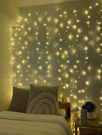 Reviewer's string lights lit up over their bed