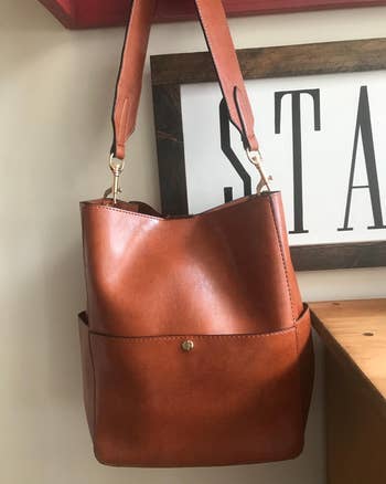 reviewer photo of the brown bucket bag with gold hardware