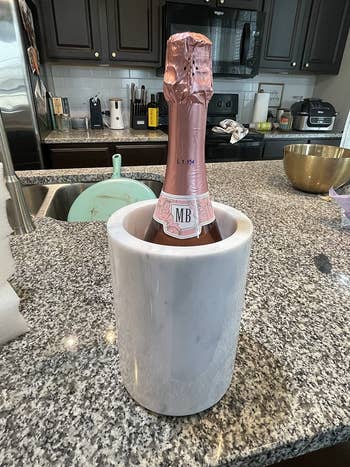 Champagne vessel  with pinkish  foil successful  a marble cooler connected  a granite room  counter, surrounded by room  utensils