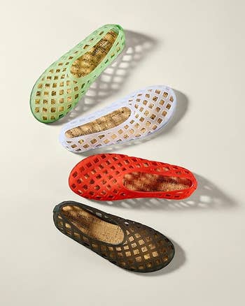 Four breathable slip-on shoes successful  green, white, red, and achromatic  are arranged connected  a neutral background. Perfect for casual deterioration  and summertime  outings