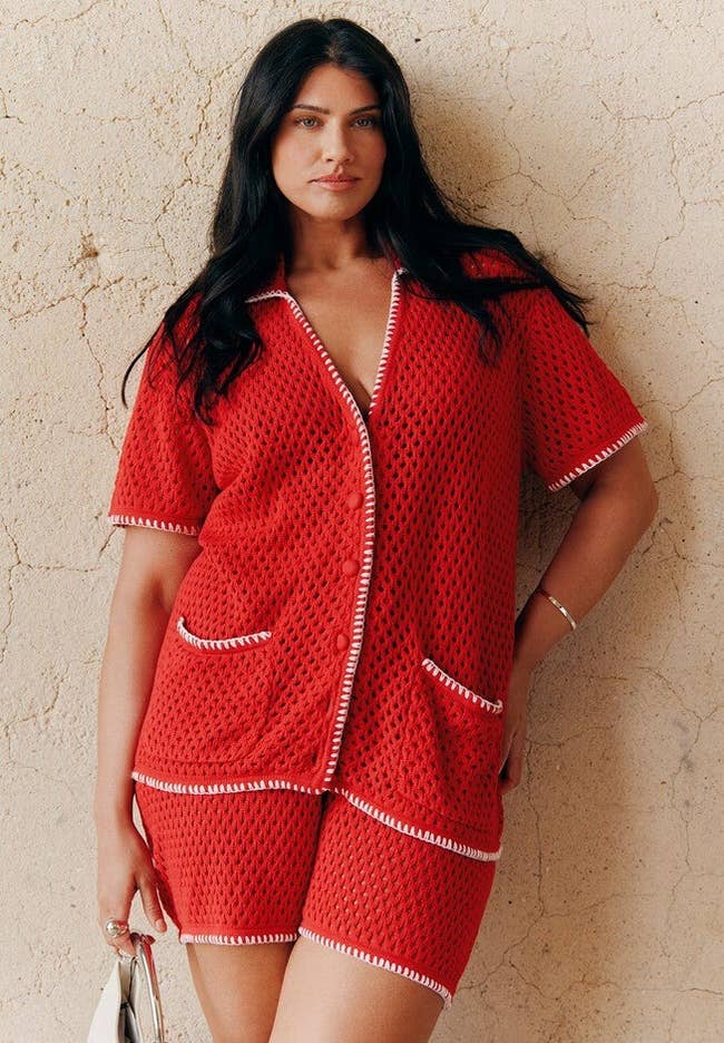 Model successful stylish textured knit short-sleeve apical and shorts with achromatic trim, holding a achromatic purse