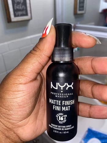 Reviewer holding their Nyx setting spray