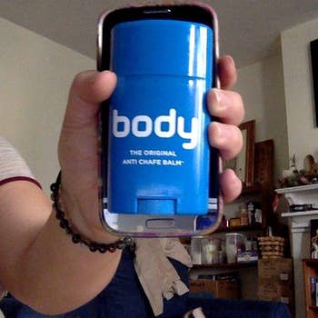 reviewer holding the body chafing stick against their phone, showing how they're about the same size