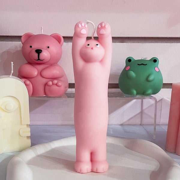 pink candle that looks like a cat stretching