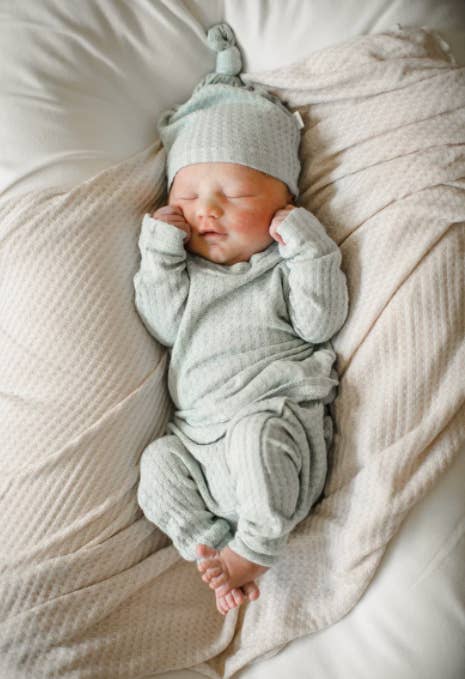 a baby in light blue waffle knit outfit