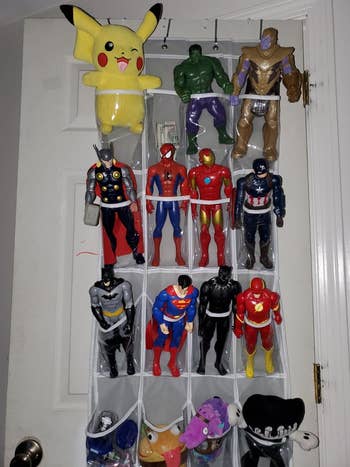 Reviewer's photo showing their kid' action figures stored in the shoe organizer