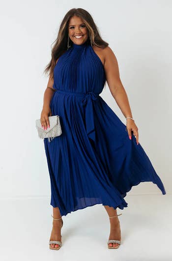 a model wearing the belted navy blue dress