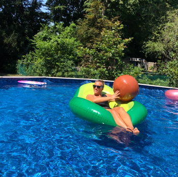 another reviewer floating in the floatie while holding the ball