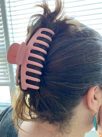 a reviewer with a pink claw clip in their hair