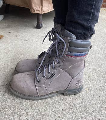 reviewer wearing the frost gray boots with jeans tucked in