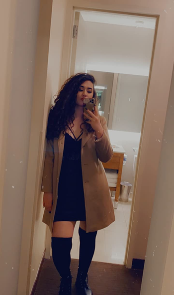 A reviewer wearing a camel colored coat