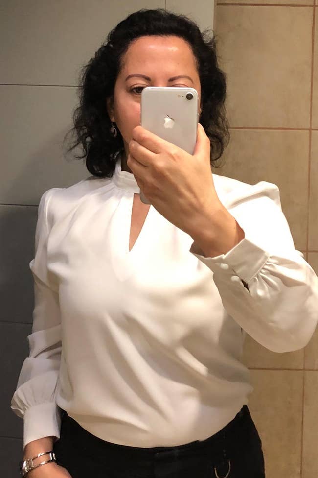 Image of reviewer wearing white long-sleeve blouse