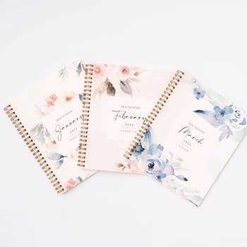 three journals with floral designs for January, February, and March