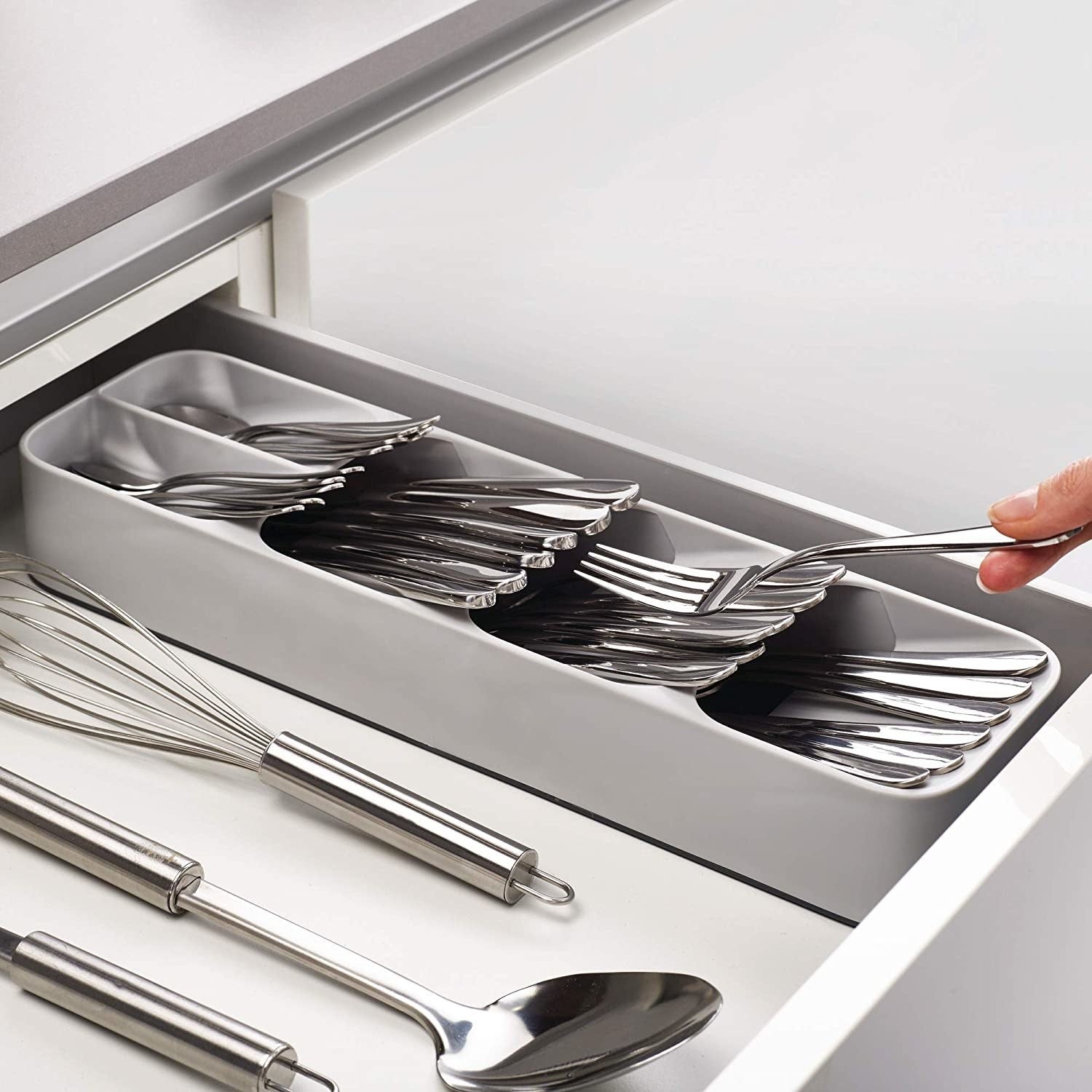 model putting silverware in the organizer