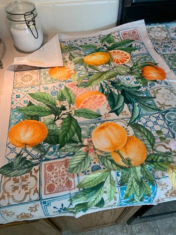 Kitchen towel featuring printed oranges and leaves