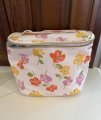 Floral patterned Kate Spade constitution  container  connected  a achromatic  surface