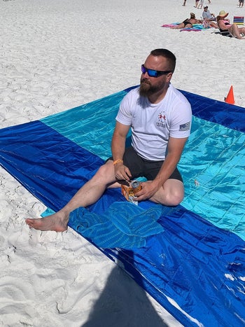 reviewer sitting on the blanket at the beach