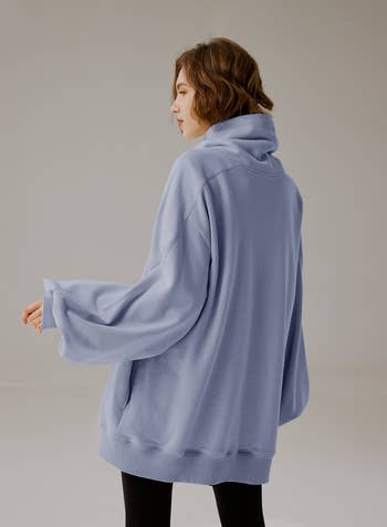 same model from the back wearing the sweater in light blue