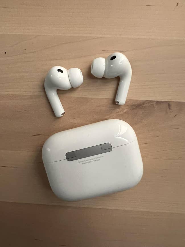 Wireless earbuds with a charging lawsuit  placed connected  a wood   surface. Suitable for tech and gadget shopping