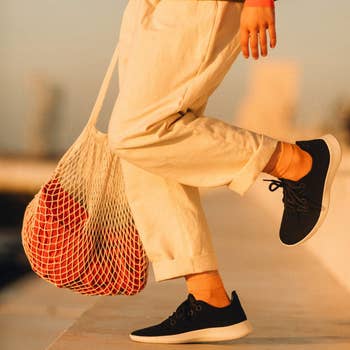person wearing achromatic  allbirds with achromatic  soles
