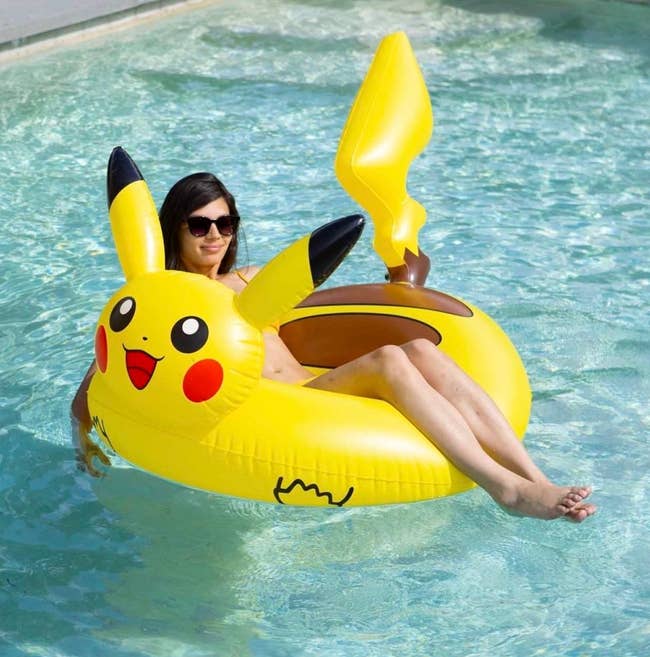 a model lounging in a pikachu pool float