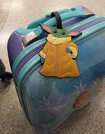 reviewer photo of Grogu luggage tag on suitcase