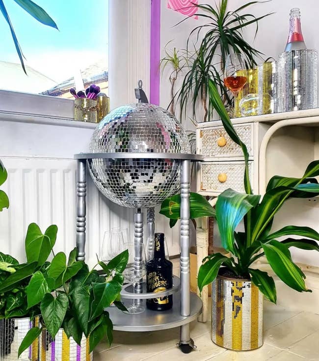 the silver disco ball bar cart surrounded by potted plants