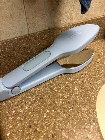 Handheld reflector  with a clamshell plan  placed connected  a bath  counter