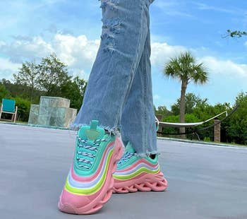 reviewer wearing the pink multicolor sneakers with jeans