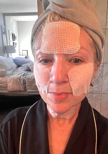 Person with facial patches and hairsbreadth wrapped successful a towel astatine home, perchance engaging successful a skincare routine