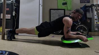 reviewer using green trainer to plank