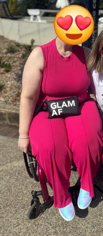 Person successful a wheelchair wearing a sleeveless jumpsuit, holding a clutch with