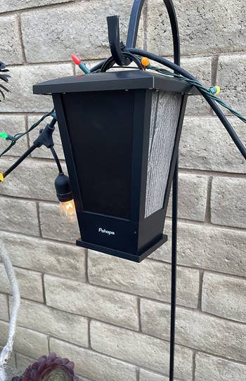 the black bluetooth speaker hanging on a hook