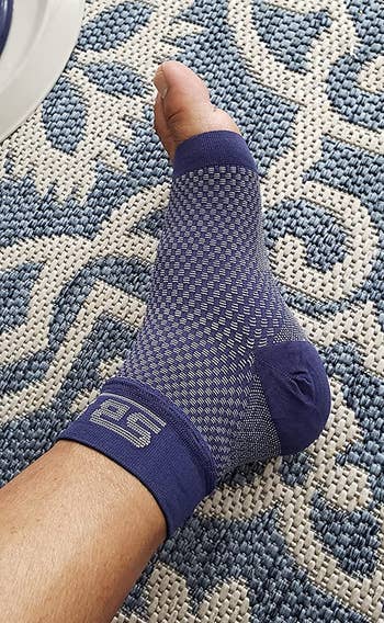 reviewer wearing blue compression sock