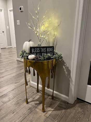 reviewer image of the gold aluminum drip table in an entryway