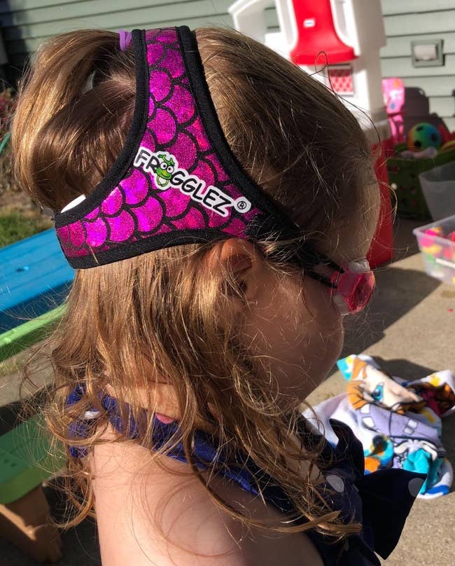 reviewer's young child wearing Frogglez swim goggles