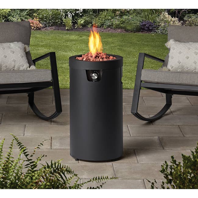 Image of the black cylindrical fire pit on a patio