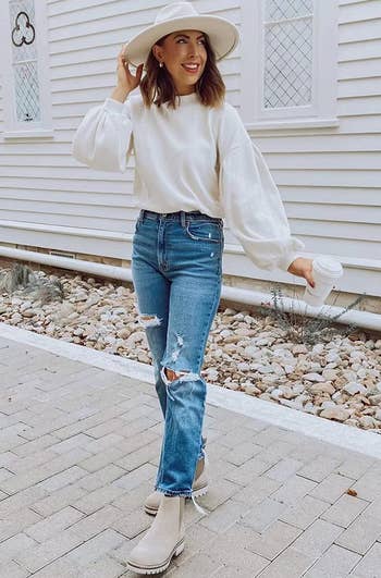 model wearing the white sweater with jeans and beige ankle boots