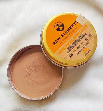 a reviewer photo of the open tin of sunscreen 