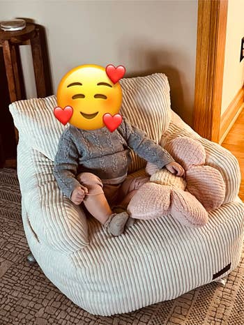A babe  sits successful  a brushed  seat  with a plush toy