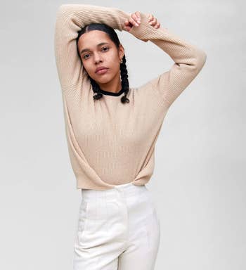 a model wearing the crewneck sweater in undyed white