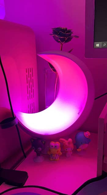 a pink glowing moon lamp in a dark room