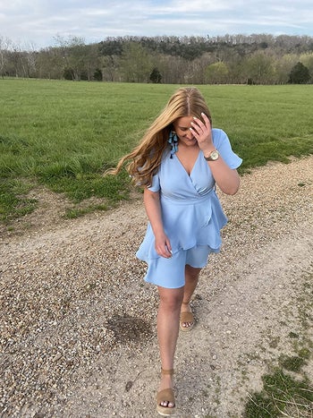 reviewer photo of them wearing the blue mini wrap dress with short sleeves