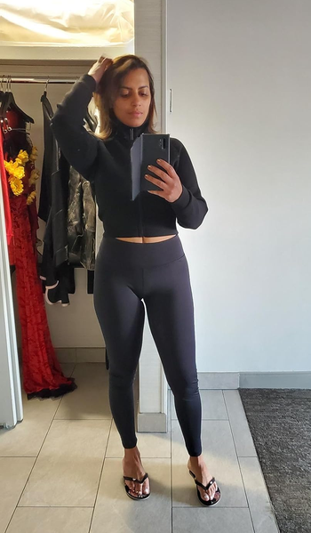 Reviewer showing how the black leggings look on them from the front