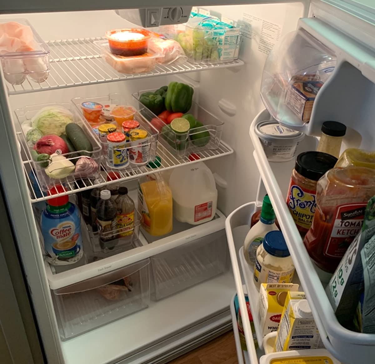 A reviewer's photo of their fridge organized with the six clear containers