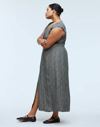 Model in a mid-length patterned dress with a side sllt 