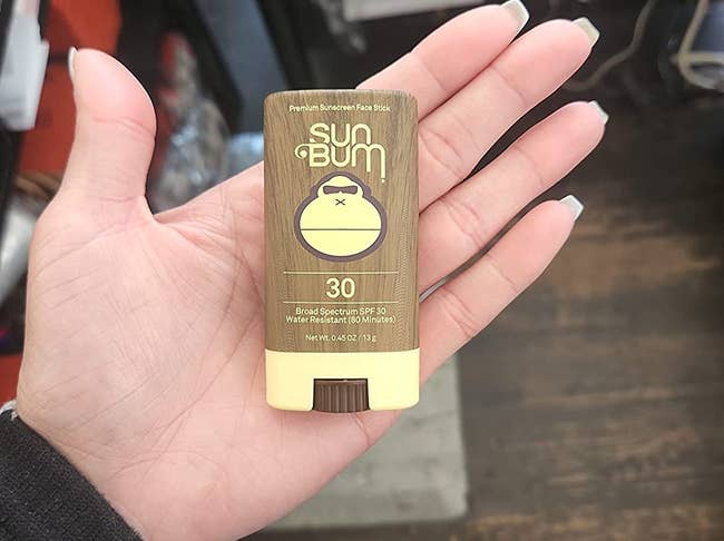 reviewer holding the sunscreen stick, which is a little bit bigger than their palm